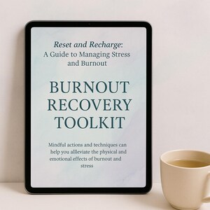 May include: A digital tablet displays the text "Reset and Recharge: A Guide to Managing Stress and Burnout" and "Burnout Recovery Toolkit." A beige mug with a light-colored beverage sits to the right.