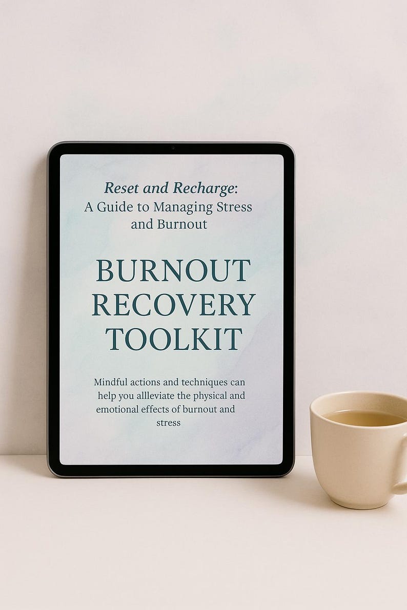 May include: A digital tablet displays the text "Reset and Recharge: A Guide to Managing Stress and Burnout" and "Burnout Recovery Toolkit." A beige mug with a light-colored beverage sits to the right.