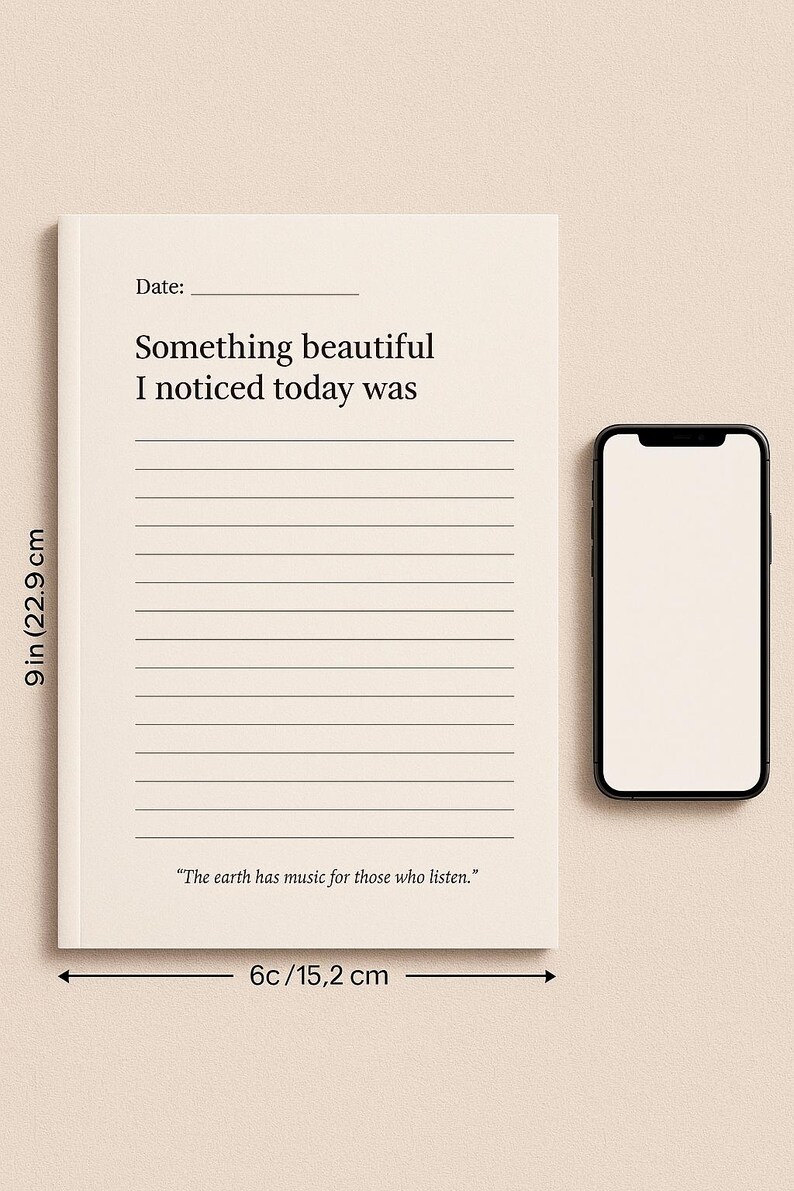 May include: A cream-colored journal with lined pages, measuring 9 inches (22.9 cm) tall and 6 inches (15.2 cm) wide, next to a smartphone. The journal's cover reads "Something beautiful I noticed today was." A quote at the bottom says, "The earth has music for those who listen."