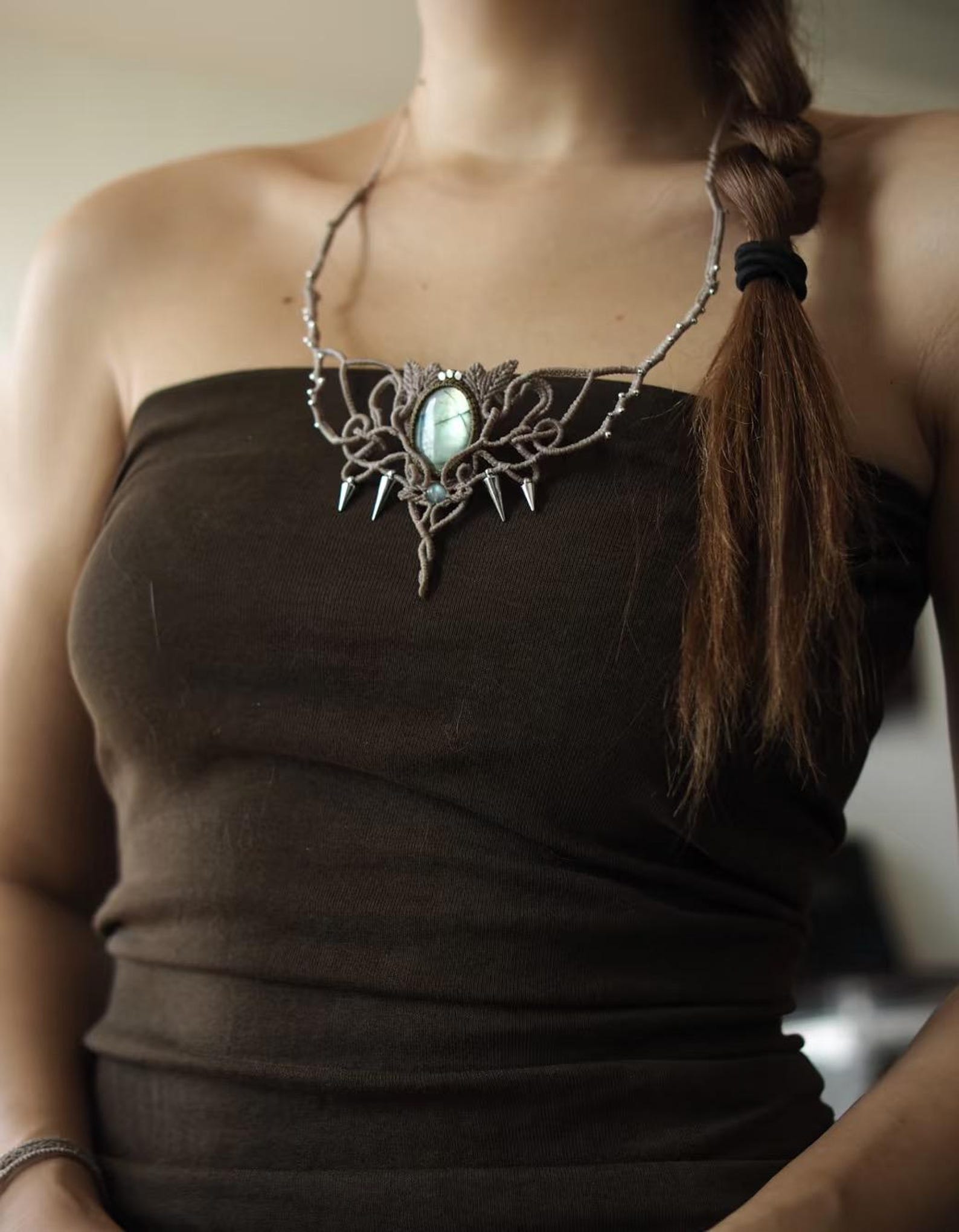 Woman wearing labradorite macrame choker with silver spikes and botanical knots.