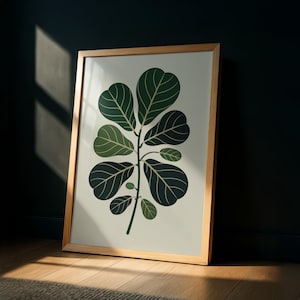 Może przedstawiać: Oprawiony wydruk artystyczny przedstawiający stylizowaną ilustrację rośliny figowca lirolistnego. Grafika przedstawia duże, ciemnozielone liście z jaśniejszymi zielonymi żyłkami na kremowym tle. Rama wykonana jest z jasnego drewna.