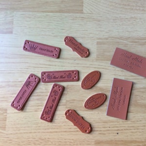 May include: Assortment of brown leather labels with various designs and text, including "Hand Made", "Special Edition", and "For You".