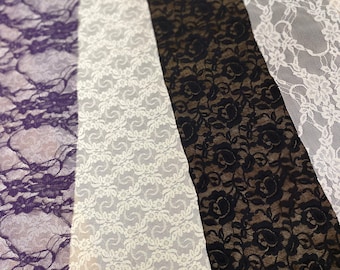May include: Five different lace trims in various colors, including purple, white, and black. The lace trims are arranged in a fan shape, with the purple trim at the top and the black trim at the bottom.