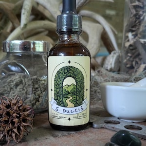 Pode incluir: Uma garrafa de vidro castanho com um conta-gotas preto, com um rótulo creme com ilustrações botânicas verdes e o texto "S. Dulcis Herbal Extract". A garrafa tem 60 ml e é prensada a frio. Outros itens incluem almofariz e pilão.