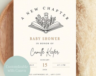Op de afbeelding: Een crème babyborrel uitnodiging met de tekst "A New Chapter" boven een illustratie van een open boek met bloemen. De uitnodiging bevat de naam "Camille Keefer", datum, tijd en contactgegevens. Een lichtblauwe cirkel met de tekst "Customizable with Canva" staat linksonder.
