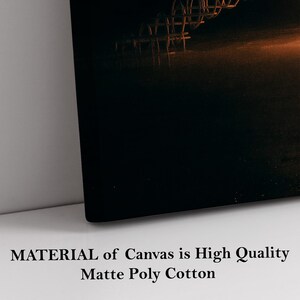 May include: A canvas print featuring a dark, abstract image with a metal structure in the upper right corner. The canvas is black with a warm, orange glow. Text at the bottom reads "MATERIAL of Canvas is High Quality Matte Poly Cotton."