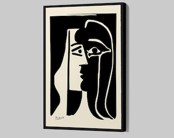 May include: Black and white framed print of a woman's profile in a modernist style. The artwork features bold lines and shapes, with the woman's face and hair rendered in black against a cream background. Signed "Picasso" in the lower left corner.