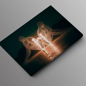 May include: A canvas print featuring a surreal artwork. Two wireframe human figures are depicted, seemingly embracing, with a bright light emanating from their center. The background is a dark teal, with a warm, golden glow.