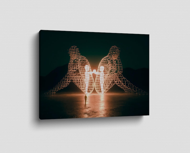 May include: A canvas print featuring a surreal landscape. Two large, wireframe figures are illuminated, each cradling a smaller figure. A lone person stands in the foreground, with a dark, moody sky and mountains in the background.