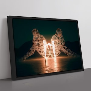 May include: Framed art print featuring two wireframe human figures facing each other, illuminated with a warm glow. A small figure stands between them. The artwork is set against a dark, moody background, creating a striking visual contrast.
