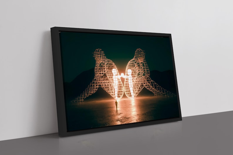 May include: Framed art print featuring two wireframe human figures facing each other, illuminated with a warm glow. A small figure stands between them. The artwork is set against a dark, moody background, creating a striking visual contrast.