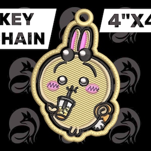 May include: Embroidered keychain featuring a cartoon bunny design with a drink. The keychain is approximately 4" x 4" in size. The bunny has pink ears and cheeks, black eyes, and is holding a drink. The words "KEY CHAIN" are displayed in white text.