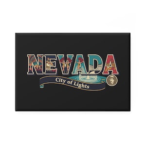 May include: A black rectangular magnet featuring the word "NEVADA" in a colorful, vintage-style design. The design includes illustrations of a cityscape, showgirls, and a tiger, with the text "City of Lights" on a banner.