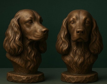 May include: Two bronze-colored dog busts. The busts depict a dog with long, wavy fur and a detailed facial structure. The busts are mounted on textured, stone-like bases. The background is a dark green.