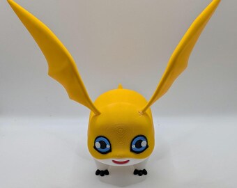 Puede incluir: Una figura de criatura amarilla con grandes orejas puntiagudas que se extienden hacia arriba. Presenta ojos azules prominentes con reflejos blancos, una boca pequeña roja y pies negros diminutos. El cuerpo es amarillo con una sección inferior blanca.