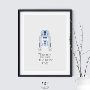 Könnte beinhalten: Ein Kreuzstichmuster mit einem Pixelbild von R2-D2, einer beliebten Figur aus dem Star Wars-Franchise. Das Muster enthält den Text "Boop beep boop boop beep bloop!" und "R2-D2".