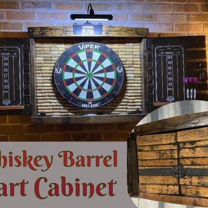May include: Whiskey barrel dart cabinet with a Viper dartboard. The cabinet has two chalkboard scoreboards and a light fixture. The cabinet doors are made of wood with metal accents. The dartboard is surrounded by a cork backing.