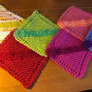 May include: Five knitted dishcloths in various colors, including red, green, pink, blue, and yellow. Each dishcloth has a different pattern and texture.