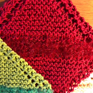 May include: A multi-colored knitted dishcloth with a red, green, and white pattern. The dishcloth is made of a soft, absorbent material and is perfect for cleaning dishes.