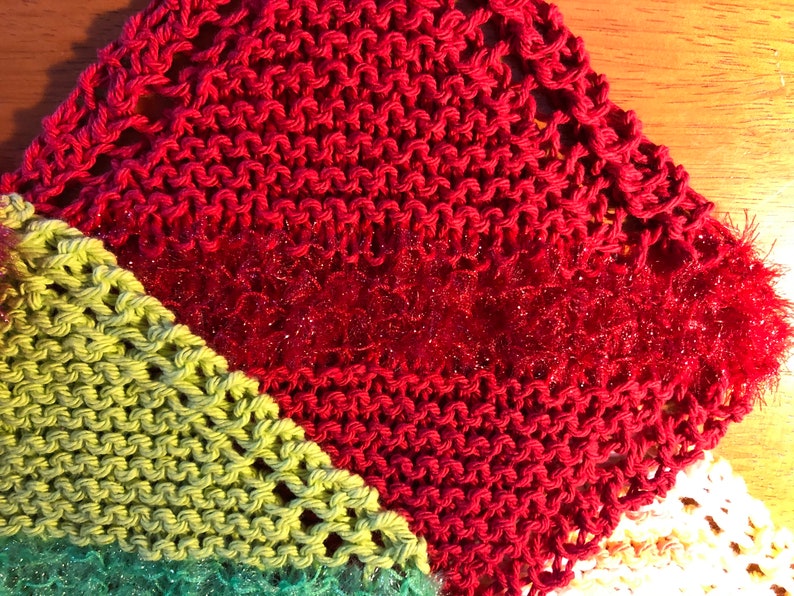 May include: A multi-colored knitted dishcloth with a red, green, and white pattern. The dishcloth is made of a soft, absorbent material and is perfect for cleaning dishes.