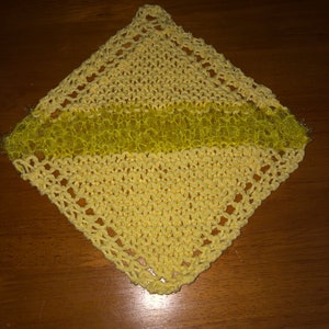 May include: A yellow knitted dishcloth with a sparkly yellow stripe in the center.