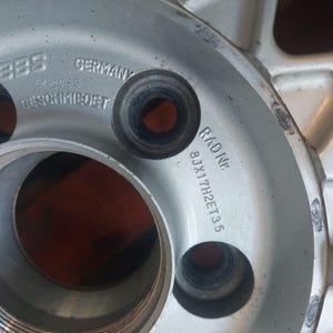 Puede incluir: Primer plano de una llanta BBS plateada. La llanta tiene varios agujeros y se ven los textos "BBS GERMANY" y "RADINE 8JX17H2ET35". La llanta parece ser de metal.
