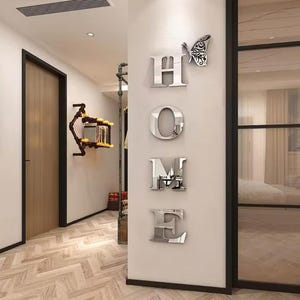 Pegatinas de pared con la letra "HOME" y mariposas en espejo plateado: decoración moderna y elegante