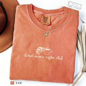 Minimalist comfort colors shirt with tired moms coffee club text and simple line art of coffee cup and croissant