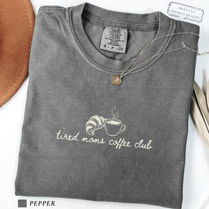 Minimal coffee mom tee with subtle design featuring cup and croissant illustration