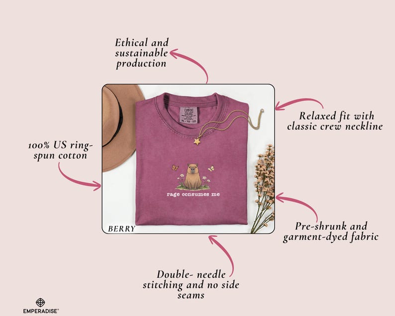 May include: Berry-colored t-shirt with a crew neckline. The shirt features an embroidered design of a small animal with the text "rage consumes me." The shirt is made of 100% US ring-spun cotton and has double-needle stitching.