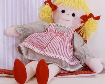 May include: A handmade rag doll with blonde yarn hair, wearing a gray and pink striped dress with a red bow on each side of her head.