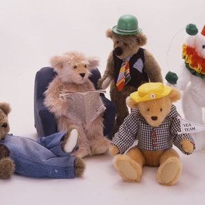 May include: Five plush teddy bears, each with a unique personality. One bear is wearing a green hat and a vest with a striped tie. Another bear is wearing a yellow hat and a checkered shirt. A third bear is wearing a clown costume with a red hat and a yellow and green ruffle. The fourth bear is wearing overalls and is lying down. The fifth bear is sitting in a blue armchair and reading a newspaper.