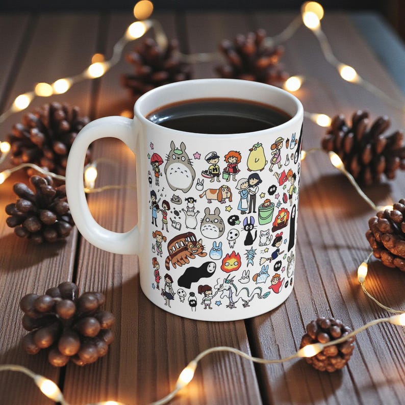 Close-up view of a cute anime mug with forest spirit and Kodama inspired illustration. Nature-themed coffee mug influenced by the magical worlds of Princess Mononoke and My Neighbor Totoro with detailed kawaii character artwork.