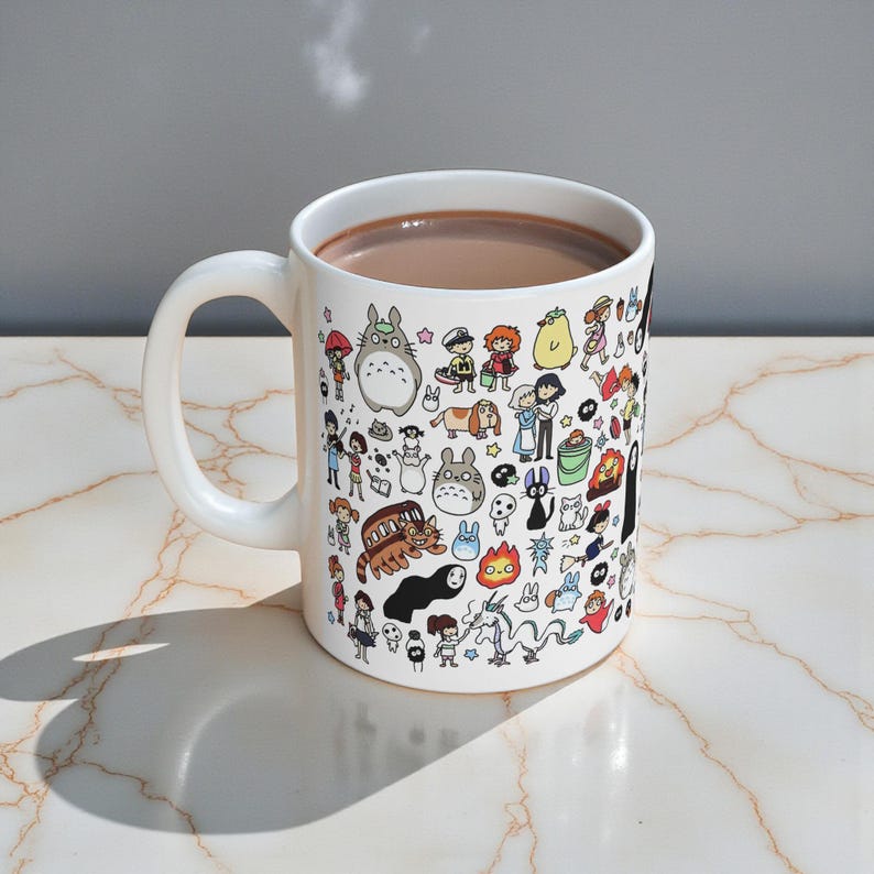 Cozy coffee scene featuring a cute anime mug inspired by magical forest spirits from Princess Mononoke and My Neighbor Totoro. Aesthetic mug perfect for anime fans and nature lovers.