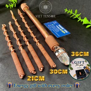 May include: Four copper rods of varying lengths, 21cm, 30cm, and 36cm, each wrapped in copper wire. The longest rod features a clear, pointed crystal at one end. A blue card with the text VIET TENSOR and THANK YOU is visible alongside a gift box graphic.