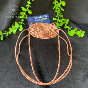 Pode incluir: Uma caneca de cerâmica branca com uma alça preta e o texto "But First, Coffee" em estilo manuscrito. A caneca está sobre uma superfície branca. A caneca tem 10 cm de altura.