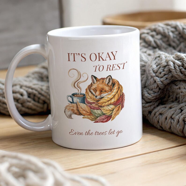 Cozy fox autumn mug in high-quality white ceramic, perfect for coffee, tea, or hot chocolate. Illustrated fox surrounded by autumn leaves, cottagecore and hygge style. A thoughtful gift for women or men, animal lovers, and woodland enthusiasts. Unique illustrated mug, durable, dishwasher and microwave safe, perfect for cozy fall vibes or as a seasonal gift idea for fox lovers and autumn home décor.
