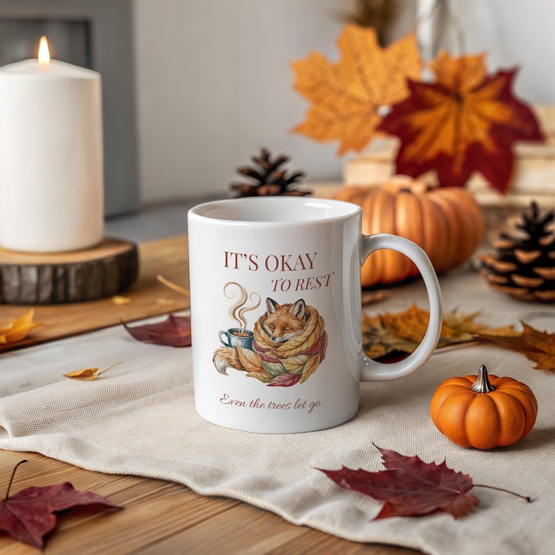 Cozy fox autumn mug in high-quality white ceramic, perfect for coffee, tea, or hot chocolate. Illustrated fox surrounded by autumn leaves, cottagecore and hygge style. A thoughtful gift for women or men, animal lovers, and woodland enthusiasts. Unique illustrated mug, durable, dishwasher and microwave safe, perfect for cozy fall vibes or as a seasonal gift idea for fox lovers and autumn home décor.