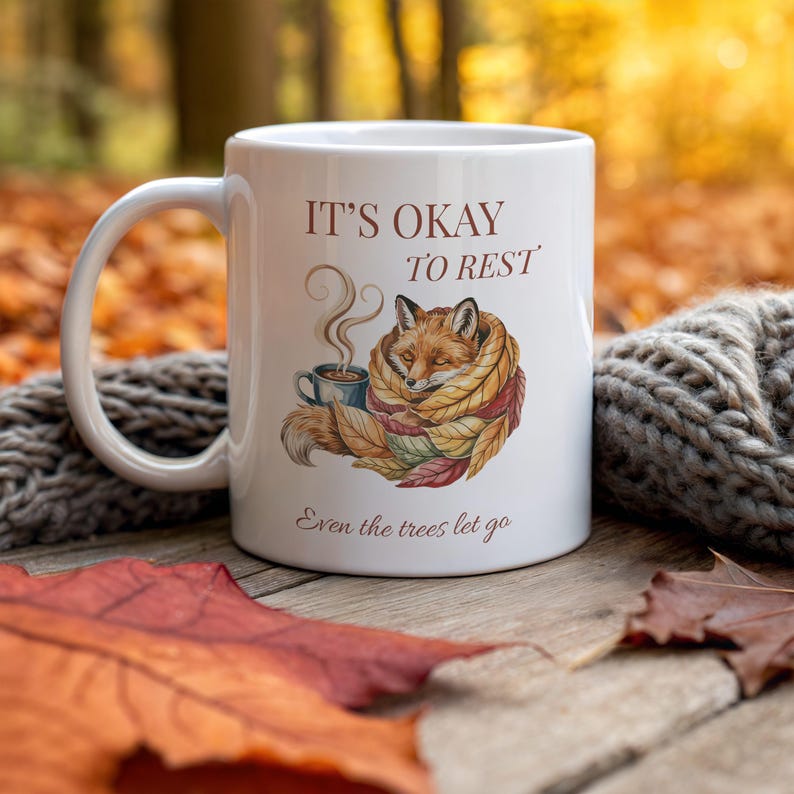 Cozy fox autumn mug in high-quality white ceramic, perfect for coffee, tea, or hot chocolate. Illustrated fox surrounded by autumn leaves, cottagecore and hygge style. A thoughtful gift for women or men, animal lovers, and woodland enthusiasts. Unique illustrated mug, durable, dishwasher and microwave safe, perfect for cozy fall vibes or as a seasonal gift idea for fox lovers and autumn home décor.