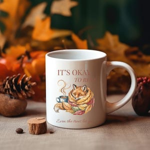 Cozy fox autumn mug in high-quality white ceramic, perfect for coffee, tea, or hot chocolate. Illustrated fox surrounded by autumn leaves, cottagecore and hygge style. A thoughtful gift for women or men, animal lovers, and woodland enthusiasts. Unique illustrated mug, durable, dishwasher and microwave safe, perfect for cozy fall vibes or as a seasonal gift idea for fox lovers and autumn home décor.