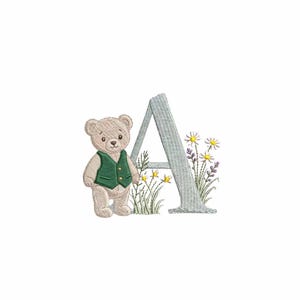 May include: An embroidered design featuring a teddy bear wearing a green vest, standing next to a light blue letter "A". The letter is surrounded by embroidered flowers and grass, creating a whimsical, nursery-themed design.