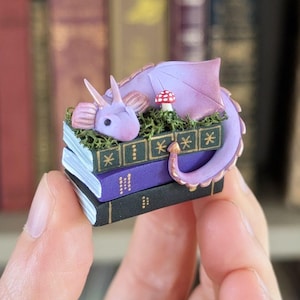 Figura de dragón de libro de fantasía, decoración de escritorio o compañero de estantería en color lavanda, verde o dorado, estatuilla de arcilla polimérica hecha a mano de 3,5 cm. Morado