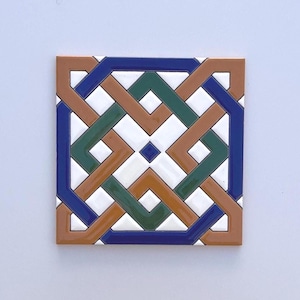 May include: Square ceramic tile with a geometric pattern in shades of brown, green, blue, and white. The design features interwoven lines and shapes, creating a symmetrical and visually appealing mosaic.