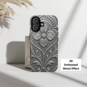 May include: A gray phone case with a 3D embossed metal effect. The case features a floral design with a central flower and symmetrical leaf patterns. The text "3D Embossed Metal Effect" is visible on a white rectangle.