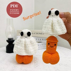 Könnte beinhalten: Gehäkelte Geister- und Kürbisfiguren mit lächelnden Gesichtern. Der Geist ist weiß mit schwarzen Augen und einem orangefarbenen Sockel. Der Kürbis ist orange. Der Text "PDF PATTERN IN ENGLISH" und "Surprise!" ist enthalten.