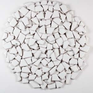 May include: A white ceramic mug with a black handle and the text "But First, Coffee" in a black, handwritten-style font. The mug is on a white surface.