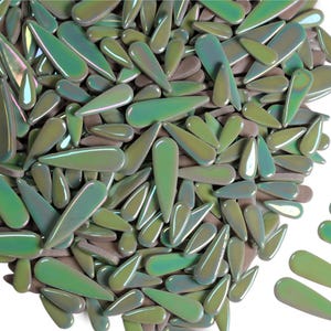 May include: A collection of iridescent, teardrop-shaped glass beads in shades of green, olive, and brown. The beads have a glossy finish and are scattered across a white background. The beads vary in size and are suitable for jewelry making or craft projects.