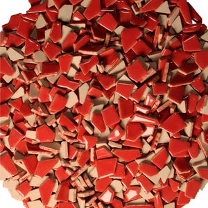 May include: A collection of red and beige ceramic tile pieces. The tiles are irregularly shaped, with a glossy red finish on one side and a matte beige finish on the other. The pieces are scattered, creating a mosaic effect.