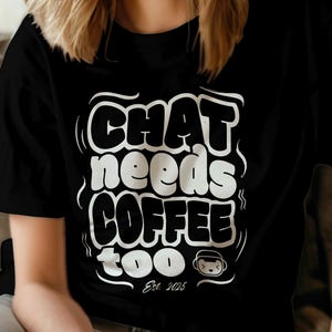 Könnte beinhalten: Schwarzes T-Shirt mit dem weißen Text "CHAT needs COFFEE too" in einer stilisierten Schriftart. Der Text enthält eine kleine Kaffeetassen-Grafik und das Jahr "Est. 2025". Ein lässiges Kleidungsstück.