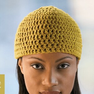 May include: A woman wearing a yellow crocheted beanie hat. The hat has a simple stitch pattern and is made of a soft, warm material.